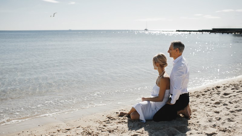 lateral-view-of-couple-which-is-sitting-on-the-sandy-beach-near-the-sea-and-looking-on-the-breathtaking-landscape.jpg